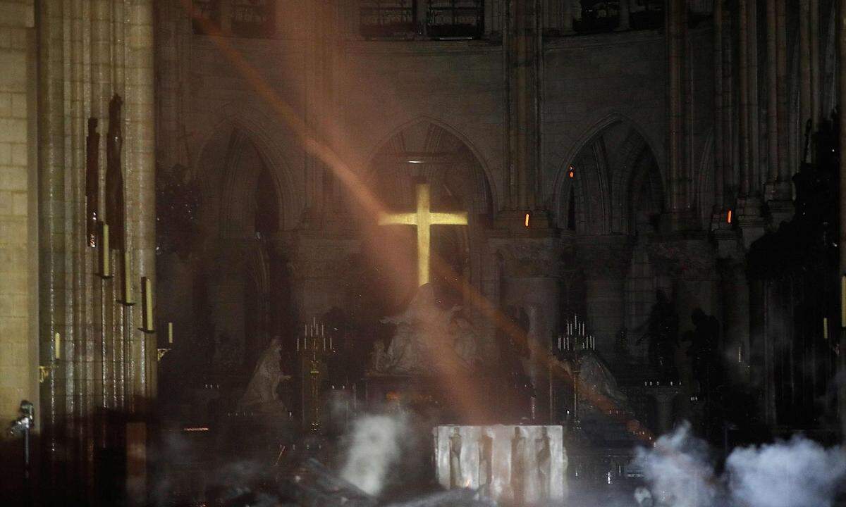 Das Kreuz hinter dem Hauptaltar scheint das Feuer einigermaßen unbeschadet überstanden zu haben. Noch ist Rauchentwicklung in der Kathedrale zu erkennen. Wie weitreichend die Schäden durch das Löschwasser sind, wird sich erst in den nächsten Tagen zeigen.