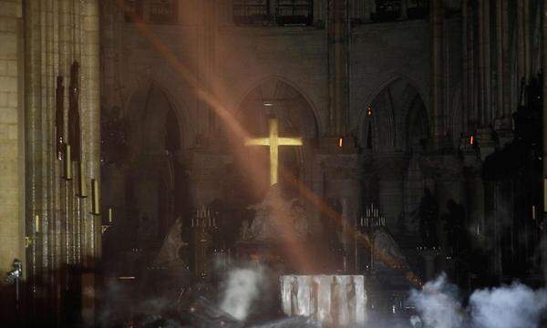 Das Kreuz hinter dem Hauptaltar scheint das Feuer einigermaßen unbeschadet überstanden zu haben. Noch ist Rauchentwicklung in der Kathedrale zu erkennen. Wie weitreichend die Schäden durch das Löschwasser sind, wird sich erst in den nächsten Tagen zeigen.