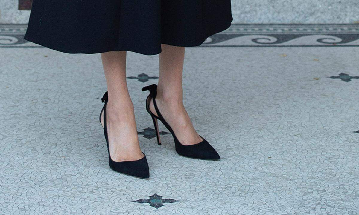 Unter dem Kleid, das ganz züchtig knapp oberhalb der Fußknöchel endet, ein weiterer Hingucker: An den spitzzulaufenden schwarzen Aquazzura-High Heels, die hinten offen sind, wurden an der Ferse kleine Schleifen angebracht – vielleicht der Grund für ihren Strumpfhosen-Boykott.