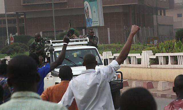 Civilians cheer as mutinous soldiers drive past in Bamako, Mali Wednesday March 21, 2012. Gunshots co