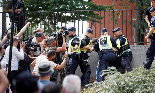 Polizisten halten Demonstranten und Medien zurück, als ein Mann in Stockholm vor der Großen Moschee den Koran verbrennt.