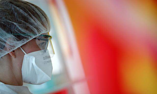A medical worker, wearing a protective face mask and a protective suit, works in a pulmonology unit at the hospital in Vannes