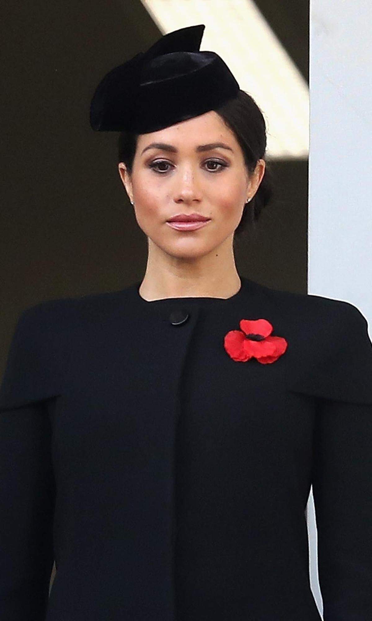 Andächtig ging es am nächsten Tag bei der Kranzniederlegung am Kriegsdenkmal am Whitehall Palast zu. Entsprechend dem Anlass war Schwarz die Farbe der Stunde. Meghan vertraute in einem maßgeschneiderten Mantel mit betonten Schultern erneut auf Givenchy. Am Reverse trägt sie als ein Symbol des Gedenkens eine "Remembrance Poppy" und am Kopf einen Pillbox-Hut aus Samt.