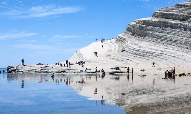 Touristen sonnen sich an der Scala dei Turchi, einem spektakulären Felsen im Süden Siziliens. Hier gibt es Meer, Berge und viel Sonne – aber wenig Jobs.