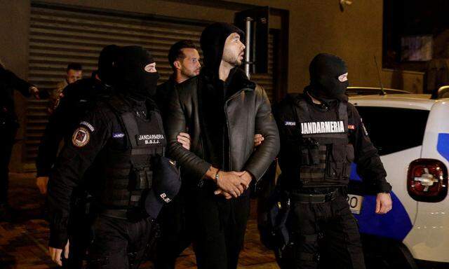 Andrew und Tristan Tate werden von Polizeibeamten vor das Hauptquartier der Direktion für die Untersuchung von organisierter Kriminalität und Terrorismus in Bukarest eskortiert