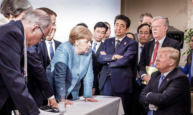 German Chancellor Merkel speaks to U.S. President Trump during the second day of the G7 meeting in Charlevoix city of La Malbaie, Quebec