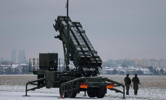 Militärs patrouillieren vor einem Luftabwehrsystem Typ Patriot auf dem Flughafen in Warschau.