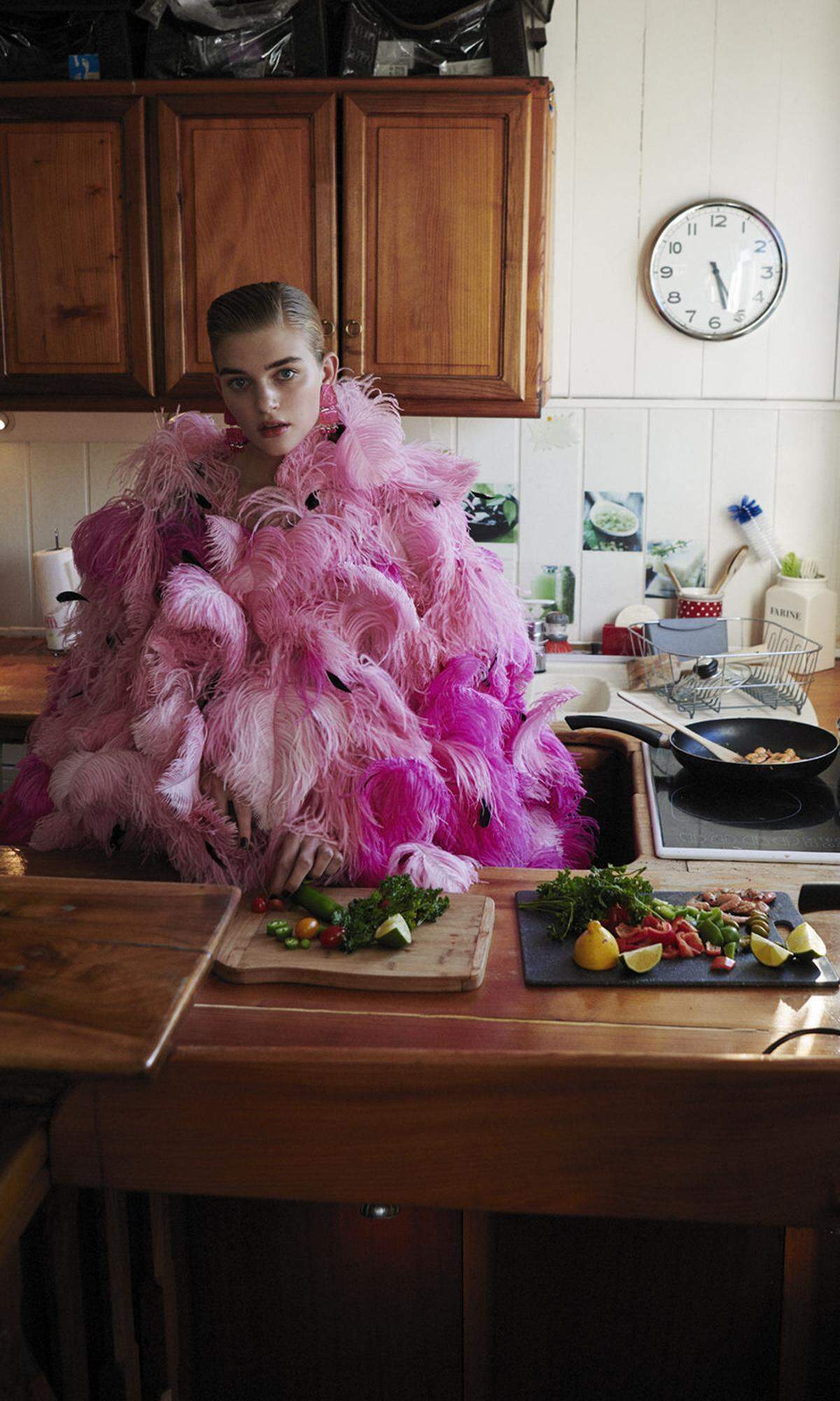 Cape aus Federn in Pink und Schwarz sowie Ohrclips von Armani Privé.