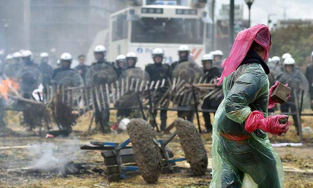 Protester prepares to throw a piece of pavement to the police as farmers and dairy farmers from all over Europe take part in a demonstration in Brussels