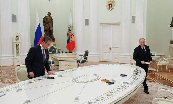 Wang und Putin sprechen über die kurze Seite des länglichen, ovalen Tisches.