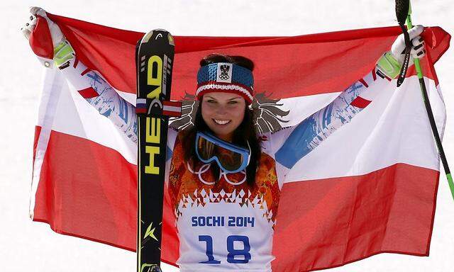 Winner Austria's Fenninger celebrates on podium during the flower ceremony for the women's alpine skiing Super G competition during the 2014 Sochi Winter Olympics at the Rosa Khutor Alpine Center 