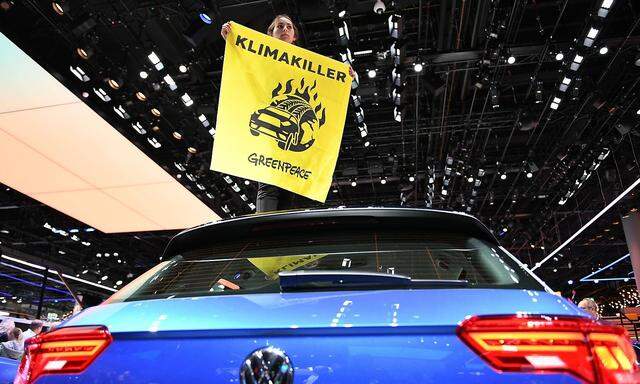 Eine Greenpeace-Aktivistin protestiert auf einer Automesse im Jahr 2019. Vier von Greenpeace unterstützte Klägerinnen und Klägern fordern, dass VW ab spätestens 2030 keine Verbrenner mehr produziert. (Archivbild)