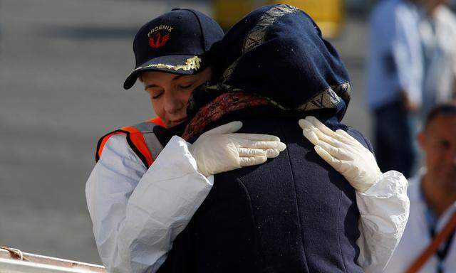 Regina Catrambone, co-founder of the Malta-based NGO Migrant Offshore Aid Station (MOAS), embraces a Syrian migrant as she disembarks from the MOAS ship Phoenix after it arrived with migrants and a corpse on board, in Catania on the island of Sicily