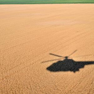 Getreide, so weit das Auge reicht. Ein Hubschrauber fliegt über ein ukrainisches Weizenfeld.