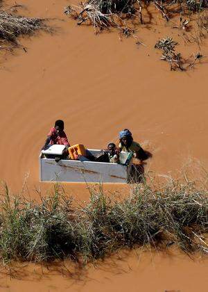 A child is transported on a fridge during floods after Cyclone Idai, in Buzi, outside Beira