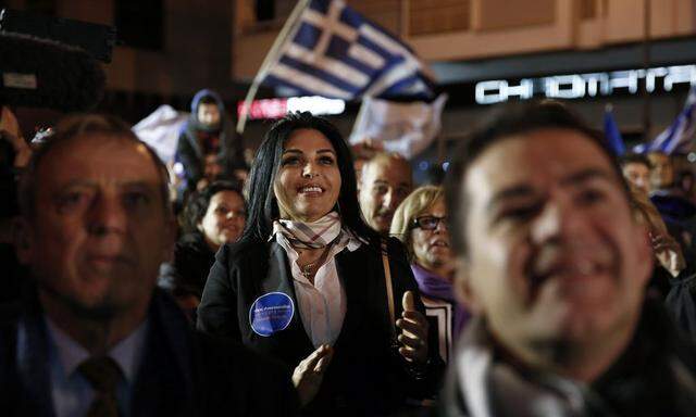 Supporters of Presidential candidate Nicos Anastasiades of the right wing Democratic Rally party watch election results on a screen outside the party's polling station in Nicosia