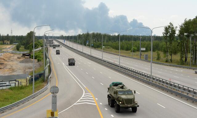 Teile der Wagner-Kolonne in aufgelockerter Fahrt nahe Woronesch. Im Hintergrund Rauch nach der Explosion eines Öldepots.