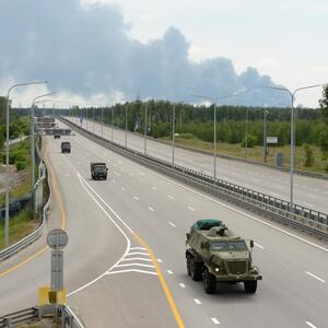 Teile der Wagner-Kolonne in aufgelockerter Fahrt nahe Woronesch. Im Hintergrund Rauch nach der Explosion eines Öldepots.