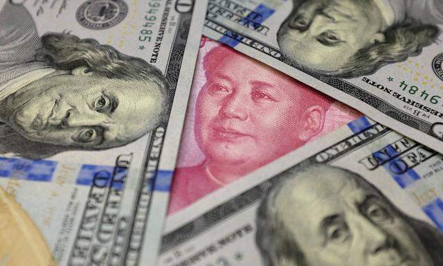 FILE PHOTO: U.S. 100 dollar banknotes and a Chinese 100 yuan banknote are seen in this picture illustration