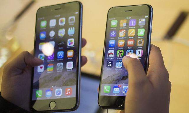 A customer holds an iPhone 6  and iPhone 6 Plus after the phones went on sale at the Fifth Avenue Apple store in Manhattan, New York