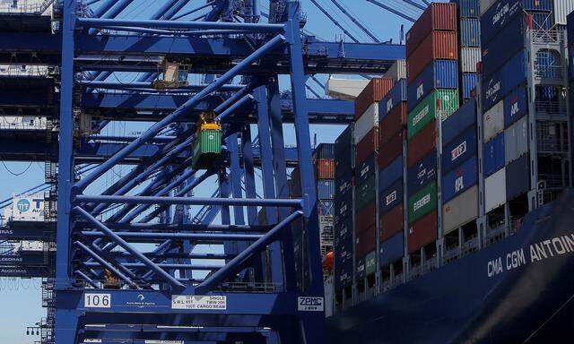 A crane loads a container on the mega cargo ship 'Antoine de Saint Exupery' at the Total Terminal International Algeciras before leaving the port of Algeciras