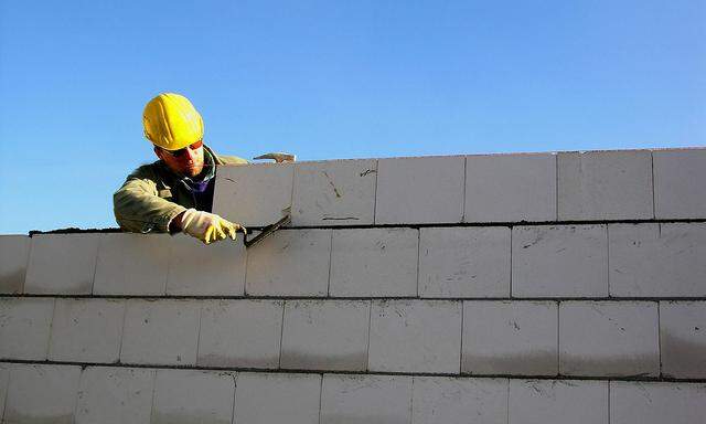 Bauarbeiter errichtet eine Ziegelmauer