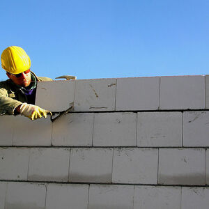 Bauarbeiter errichtet eine Ziegelmauer