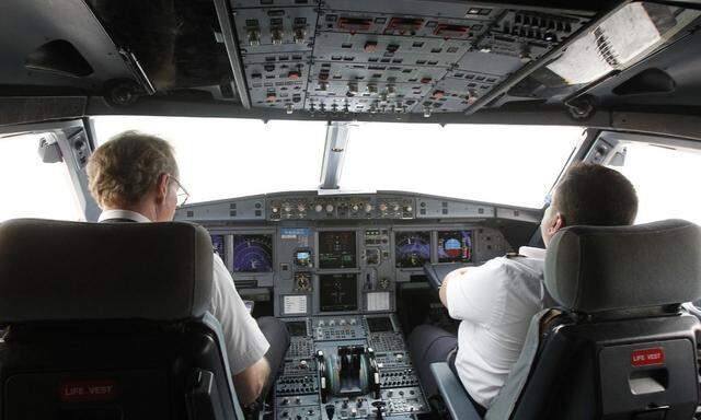 Pilots sit at the cockpit of a VietJet  A320 airplane before departure for Bangkok at Noi Bai international airport in Hanoi