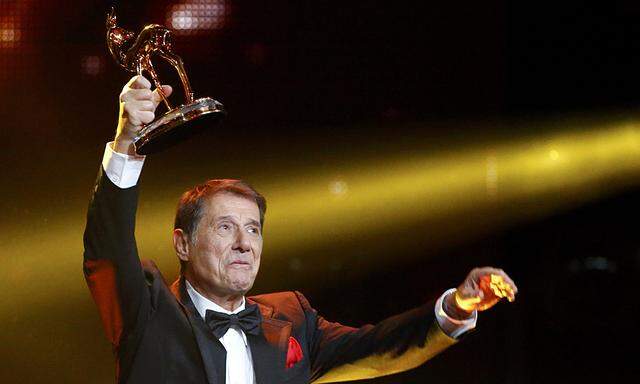 Juergens holds up his trophy for Lifetime Achievement during Bambi 2013 media awards ceremony in Berlin