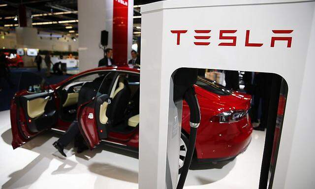 A Tesla model S car with an electric vehicle charging station is displayed at Frankfurt Motor Show in this file photo