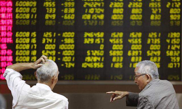 A man watches a board showing stock prices at a brokerage office in Beijing