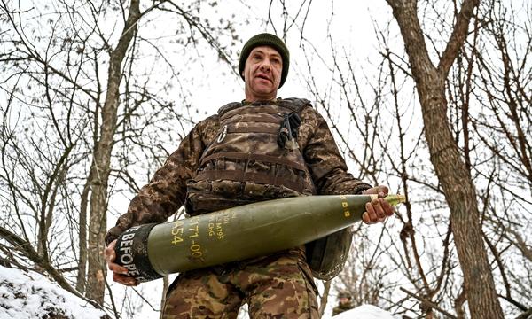 Ein ukrainischer Soldat mit einer Artilleriegranate