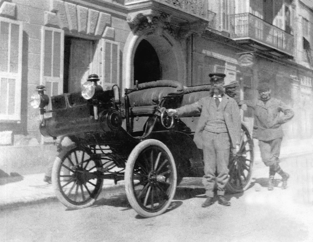 Noch ganz die „pferdelose Kutsche“: Emil Jellinek und sein Chauffeur Hermann Braun in Baden bei Wien. Der Daimler „Riemenwagen“ ist ein 6-PS-Doppel-Phaeton aus dem Jahre 1897, das erste Fahrzeug der Daimler-Motoren-Gesellschaft, das Jellinek erwirbt.