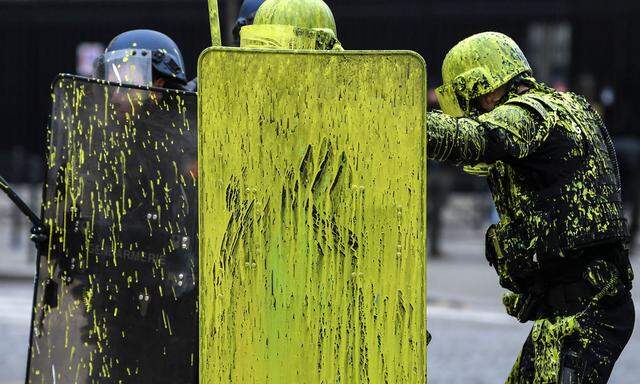 „Mutig“ und „gefährlich“ nennt Mediävist Michel Pastoureau die Farbwahl der Gelbwesten („gilets jaunes“). Polizisten auf den Champs-?lysées werden hier von ihnen mit Farbe überschüttet.