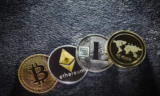 Muenzen der Kryptowaehrungen Bitcoin Ethereum Litecoin und ripple liegen auf einem Tisch Berlin