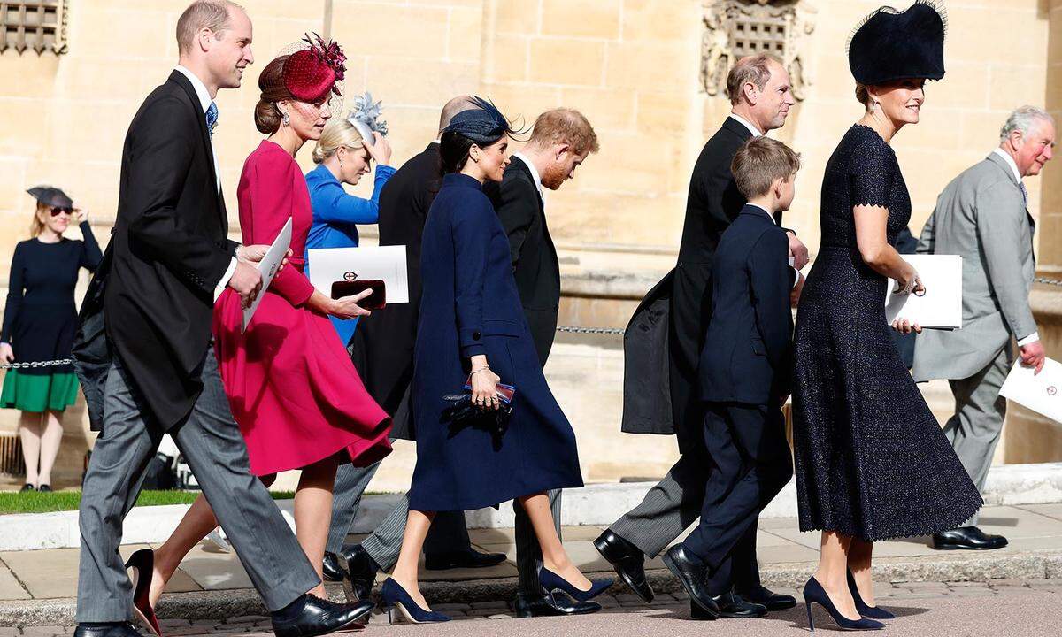 Im Gegensatz zu ihrer Schwägerin Herzogin Catherine, die sich für eine farbenfrohe Kreation von Alexander McQueen entschieden hat, setzt Meghan in einem eleganten dunkelblauen Ton-in-Ton-Ensemble samt Kleid und Mantel auf Zurückhaltung.