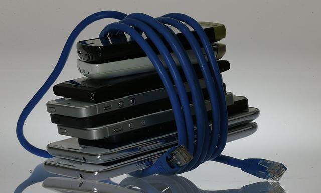 An illustration picture shows a network cable wrapped around to a pack of smartphones in Berlin