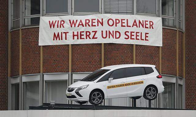 A banner reading 'We were Opel employees with heart and soul' is seen in front of the Opel plant on its final day of production in Bochum 