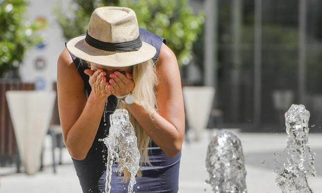 A woman refreshes herself in the public fountain in Pilsen, Czech Republic, on Tuesday, July 19, 2022. (CTKxPhoto/Miros