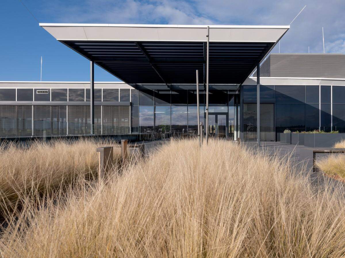 Der Neubau befindet sich auf einem zwölf Hektar großen Grundstück und besteht aus drei zusammenhängenden Bauteilen. Die großzügige Außenanlage samt Streuobstwiese und einem Schwimmteich soll für ein gutes Mikroklima am Areal sorgen.