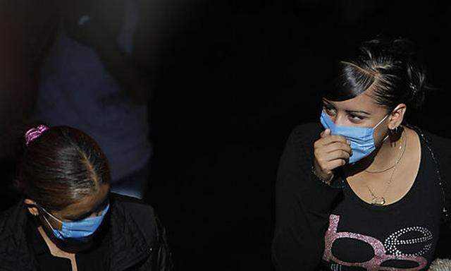 Women wear surgical masks as they exit the subway in Mexico City, Saturday, April 25, 2009. Mexico Ci