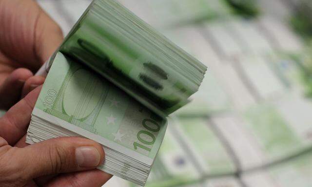 An employee of GSA Austria holds a wad of 100 euro banknotes at the company's headquarters in Vienna