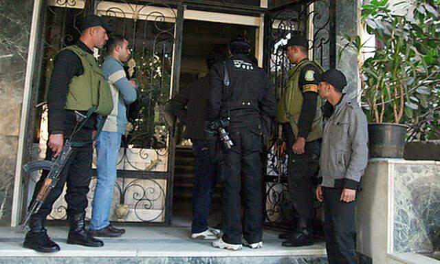 Egyptian military stand guard as officials raid one of the non-governmental organization offices in C