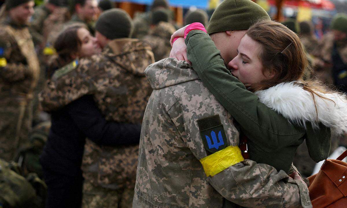 9. März. Olga umarmt ihren Freund Wlodomyr, als sie sich vor dessen Einsatz näher an der Frontlinie inmitten der russischen Invasion in der Ukraine am Bahnhof in Lwiw, Ukraine, verabschieden