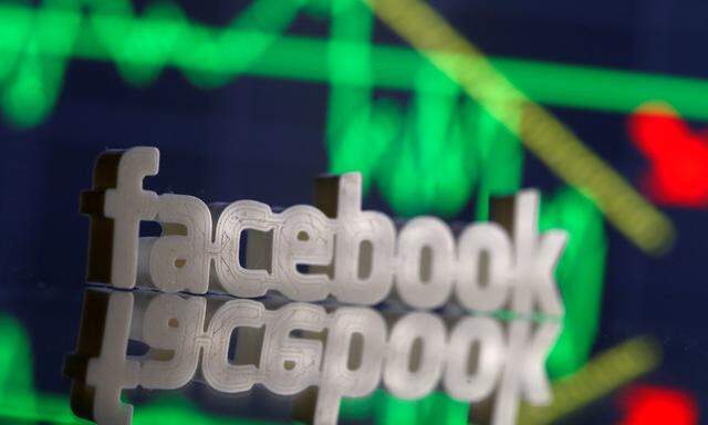 FILE PHOTO: A 3D-printed Facebook logo is seen in front of displayed stock graph