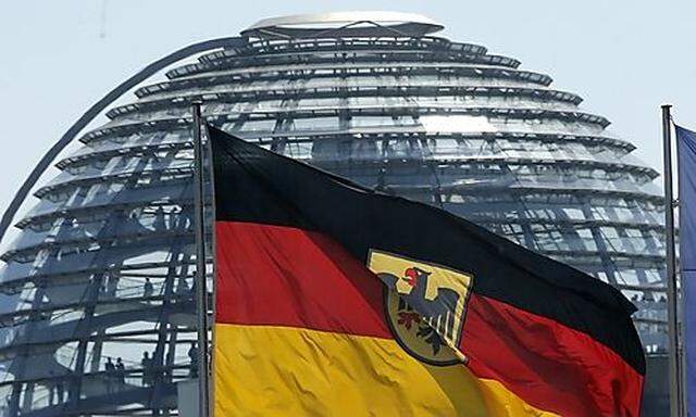 The German and the European Union flags are pictured in front of the cupola on top of the Reichstag building in Berlin