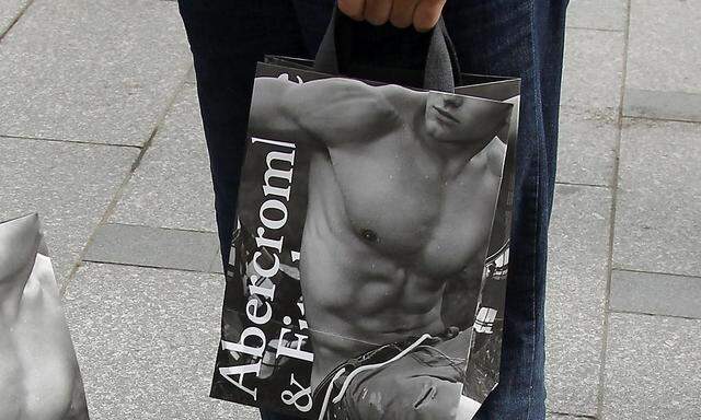 File photo of shoppers holding bags with clothing purchases on the opening day of operations by retailers Abercrombie & Fitch outside their Paris store