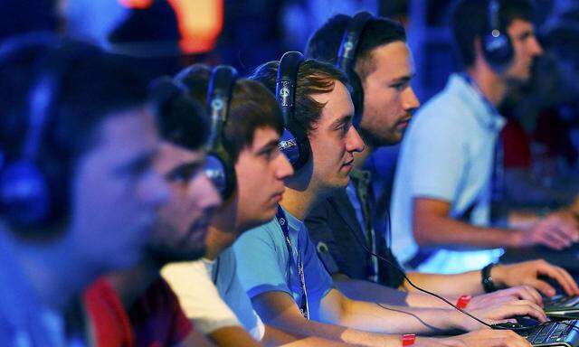 Visitors play 'Heroes of the Storm', developed by video game producer Blizzard Entertainment, using PCs during the Gamescom fair in Cologne