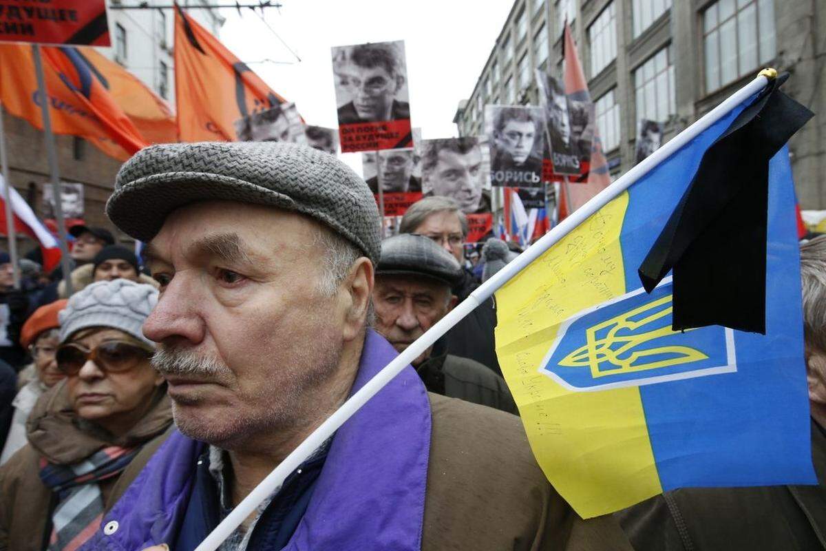 Eigentlich hätte am Sonntag in Moskau gegen Russlands Ukraine-Poltik demonstriert werden sollen. Doch dann fielen die tödlichen Schüsse. Einige Teilnehmer hatten deshalb die ukrainsiche Fahne mitgebracht.
