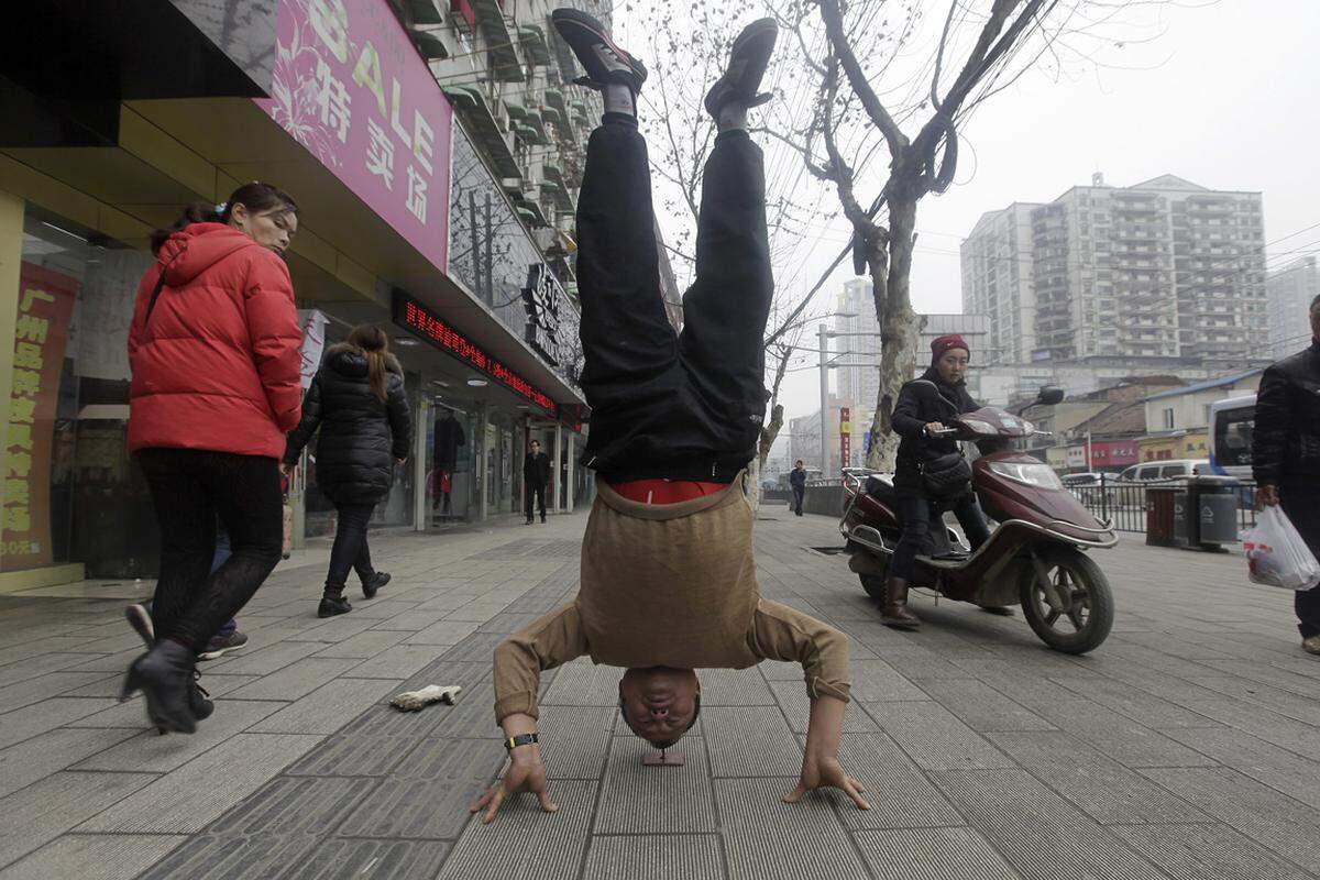 Xu Tiancheng macht auf einem Gehsteig der chinesischen Stadt Wuhan einen Kopfstand. Das Verwunderliche daran: Er balanciert auf einem Nagel. Der 56-Jährige trainiert seit fünf Jahren Qigong.